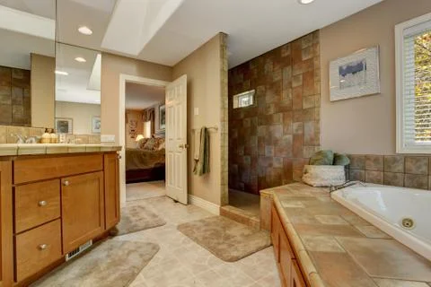 Spacious bathroom with corner bath tub and open shower Stock Photos