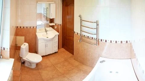 Spacious bathroom in gray tones with heated floors, freestanding tub, walk-in Stock Photos