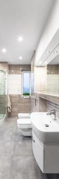 Spacious beige bathroom Stock Photos