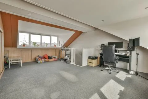 Spacious bright attic room for work and relaxation Stock Photos