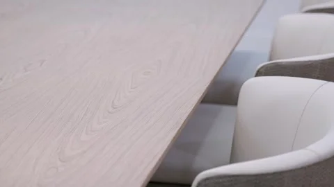 Spacious bright wooden table with white dining chairs in classic scandinavian Stock Footage 245770302