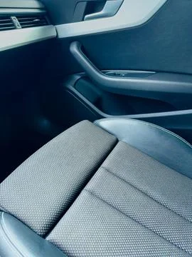 A spacious car interior highlights a plush seat with intricate fabric pattern 스톡 사진