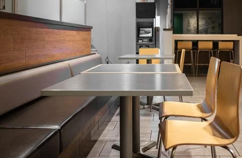 Spacious dining area with a communal table and comfortable seating in a resta Stock Photos