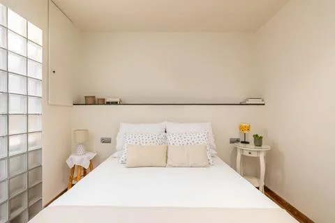 Spacious double bed in compact bedroom with coffee table and rustic lamp with Photos
