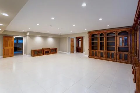 Spacious empty basement area with large custom built bookcase. Luxury lifesty Stock Photos