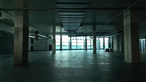Spacious empty construction site interior with concrete columns and large Vidéo 295334136