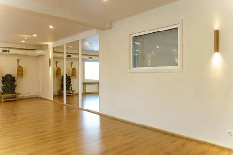 A spacious empty hall with columns and large windows. A gym with wooden floor Stock Photos
