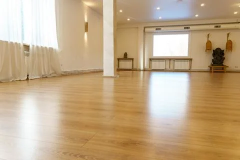 A spacious empty hall with columns and large windows. A gym with wooden floor Stock Photos