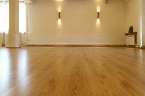 A spacious empty hall with columns and large windows. A gym with wooden floor Stock Photos