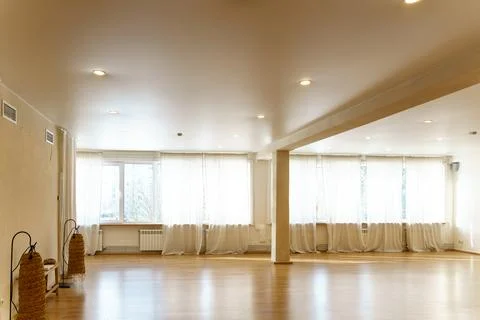 A spacious empty hall with columns and large windows. A gym with wooden floor Stock Photos