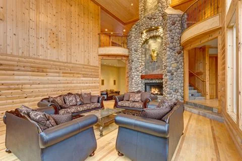 Spacious great room features pine paneled walls, amazing large stone fireplac Stock Photos