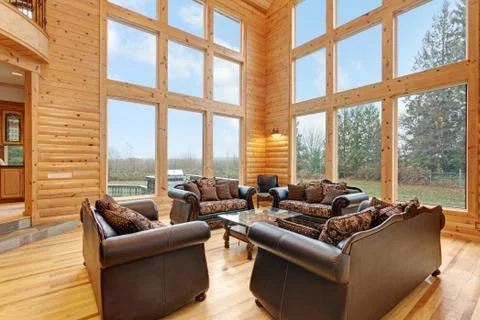 Spacious great room features pine paneled walls, Two-Story Windows and furnis Stock Photos