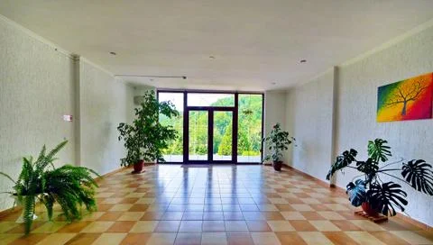 A spacious hall with a balcony, multi-colored tiles on the floor and ornament Stock Photos