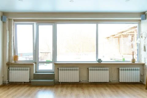 A spacious hall with large windows and radiators. Panoramic windows made of f Foto stock