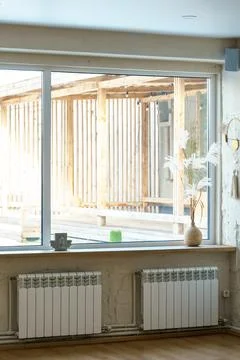 A spacious hall with large windows and radiators. Panoramic windows made of f Stock Photos