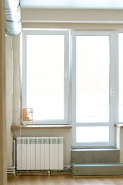 A spacious hall with large windows and radiators. Panoramic windows made of f Stock Photos