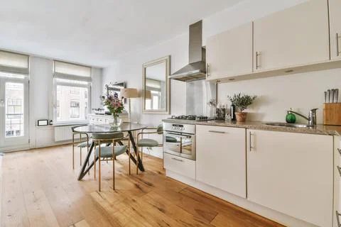 Spacious kitchen interior with elegant round dining table and chairs Stock Photos