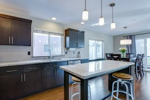Spacious kitchen with open floor plan features chocolate brown cabinets and a Foto stock