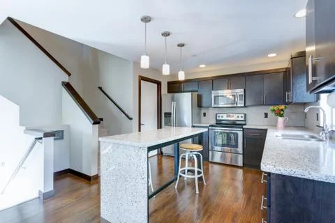 Spacious kitchen with open floor plan features chocolate brown cabinets and a Stock Photos