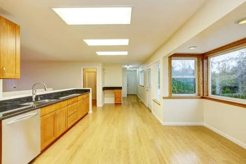 Spacious kitchen room with light brown cabinets and black granite counter top Stock Photos