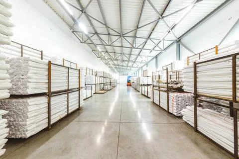 Spacious light interior of a large warehouse in a factory with special racks and Stock Photos
