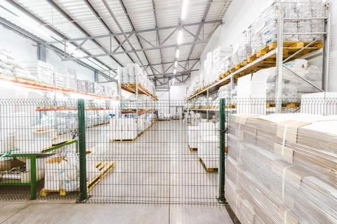Spacious light interior of a large warehouse in a factory with special racks and Stock Photos