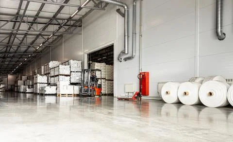 Spacious light interior of a large warehouse in a factory with special racks and Stock Photos