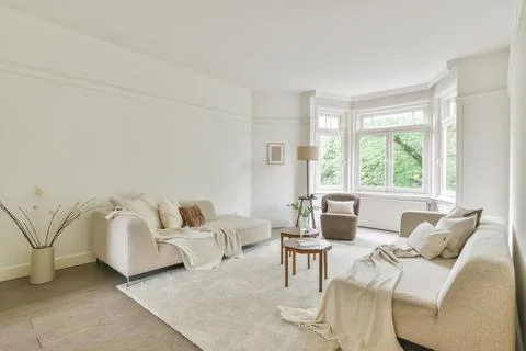 A spacious living room with comfortable sofas and other modern elements of in Stock Photos