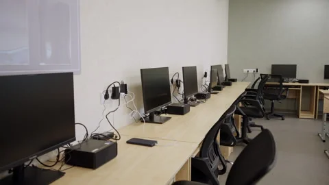 Spacious office features long wooden desks with monitors Vídeos de archivo 332736617