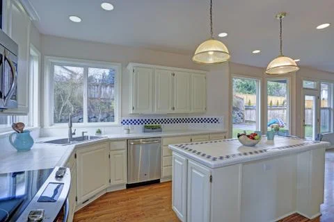 Spacious open floor plan kitchen interior with white shaker cabinets framing  Stock Photos