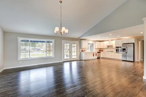 Spacious rambler home interior with vaulted ceiling over glossy laminate floo Stock Photos
