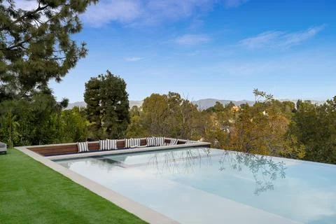 Spacious rectangular pool in a residential backyard. Stock Photos