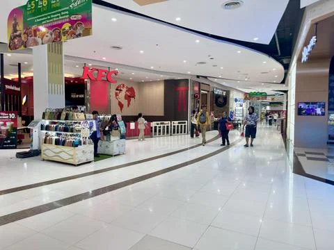 Spacious shopping corridor featuring KFC restaurant and handbag stall inside Stock Photos