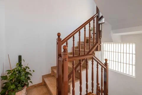 Spacious staircase with marble steps and wooden railings leading to upper floor 스톡 사진