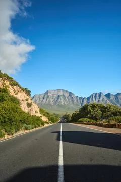 Spacious Thoroughfare Extends Toward Towering Summits Amidst Striking Cerulean 库存照片