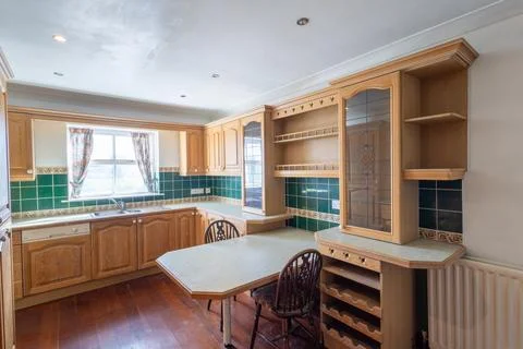 Spacious traditional 1990s fitted kitchen with wooden cabinets green tiled .. Foto stock