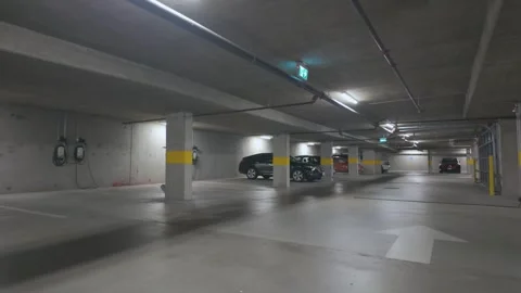 Spacious underground parking lot with few parked cars and clear markings Stock Footage 293097178