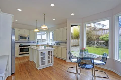Spacious white kitchen and breakfast nook interior with tons of natural light Stock Photos