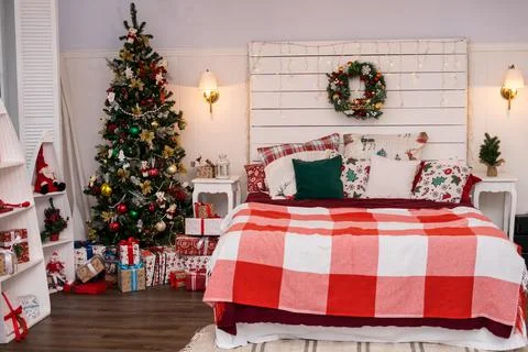 Spacious white light bedroom in a loft style with a decorated Christmas spruc Stock Photos