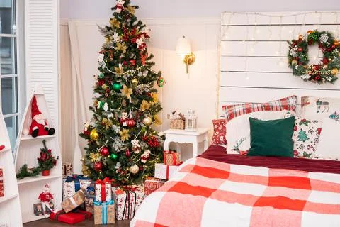 Spacious white light bedroom in a loft style with a decorated Christmas spruc Stock Photos