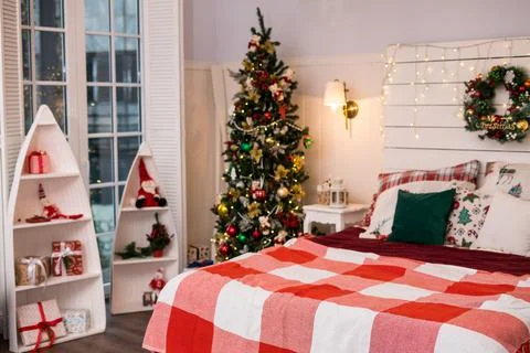 Spacious white light bedroom in a loft style with a decorated Christmas spruc Stock Photos