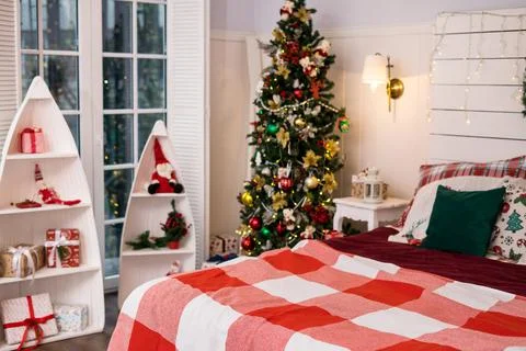 Spacious white light bedroom in a loft style with a decorated Christmas spruc Stock Photos
