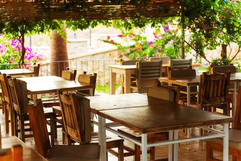 A spacious wooden deck that features tables and chairs arranged on it Stock Photos