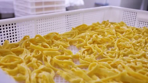 Spaetzle egg noodles process laying out to dry in tray, mass production Stock Footage 255709004