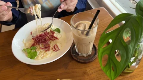 Spaghetti and coffee on the table being eaten by a woman Stock Footage 168921146