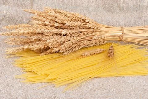 Spaghetti and wheat ears on sacking Stock Photos