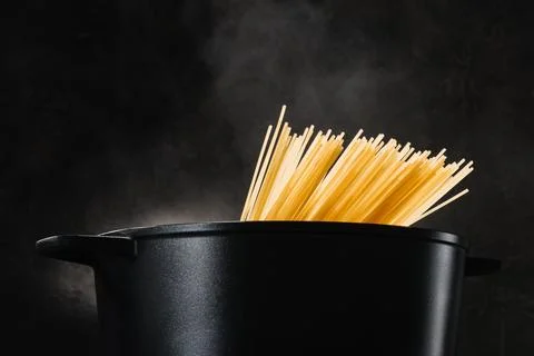 Spaghetti boiling black pan dark Stock Photos