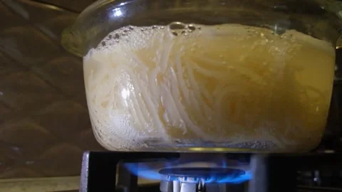Spaghetti boils in a pan. Spaghetti in a transparent pan close-up. Spaghetti in Stock Footage 283630463