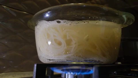 Spaghetti boils in a pan. Spaghetti in a transparent pan close-up. Spaghetti in Stock Footage 284174499
