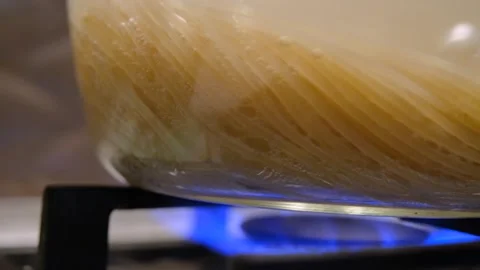 Spaghetti boils in a pan. Spaghetti in a transparent pan close-up. Spaghetti in Stock Footage 307314273